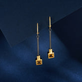 A pair of silver earrings with gold, black rhodium and yellow citrine stones.